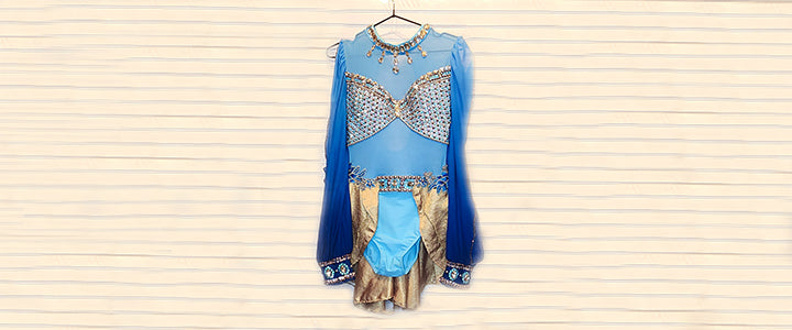 Blue and gold dress with intricate patterns on a striped background